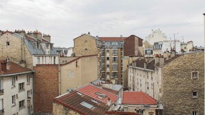 Ein dicht bebautes Stadtgebiet mit mehrstöckigen Gebäuden, einige mit Balkonen und andere mit flachen Dächern.