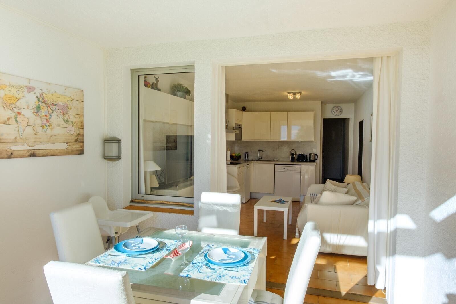 Un espace de vie compact comprenant un coin repas, une kitchenette et une petite salle de bain.