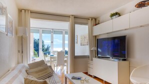 Een moderne woonkamer met een bank, televisie en uitzicht op het landschap.