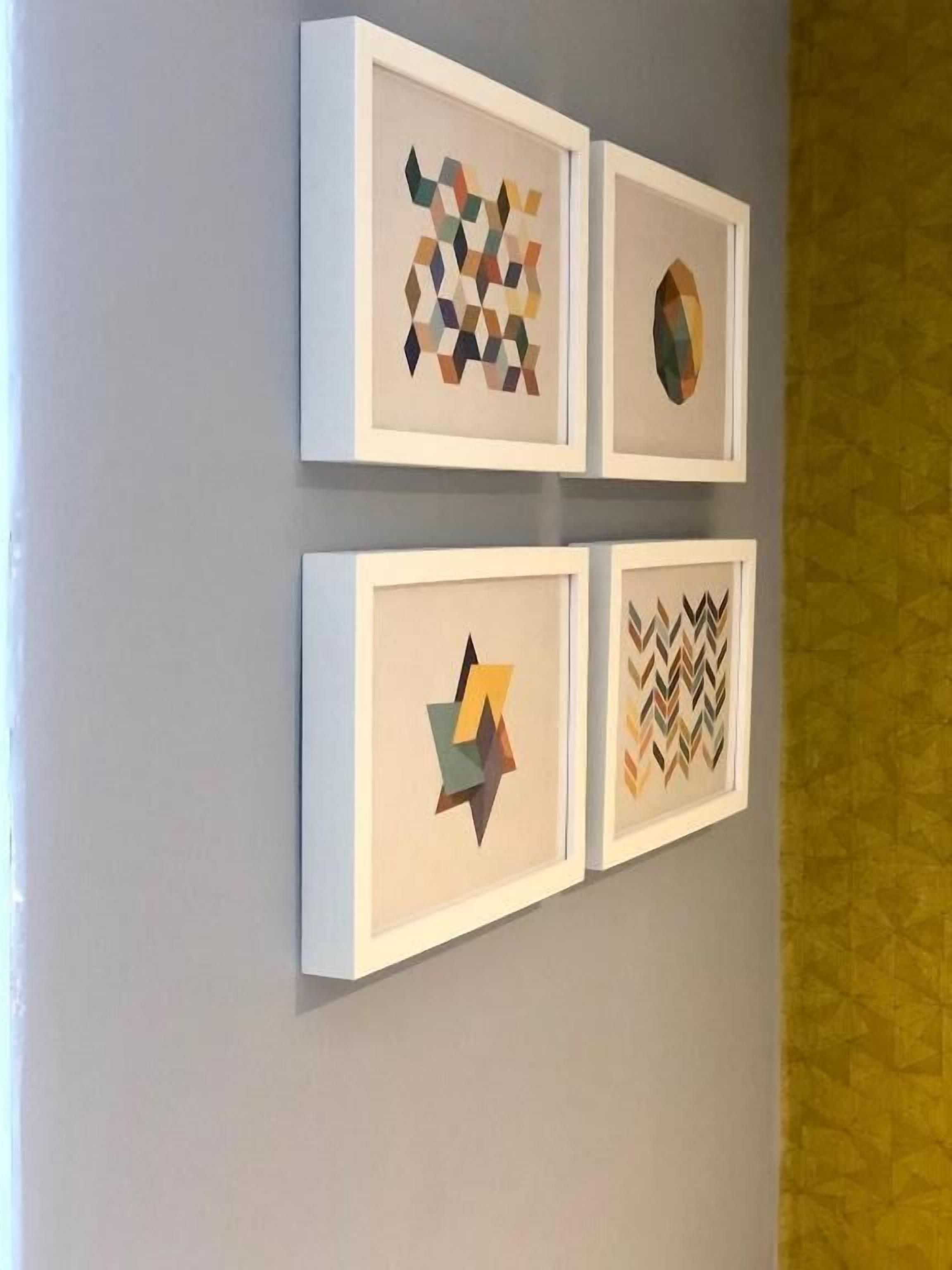 Cuatro obras de arte enmarcadas en una pared.