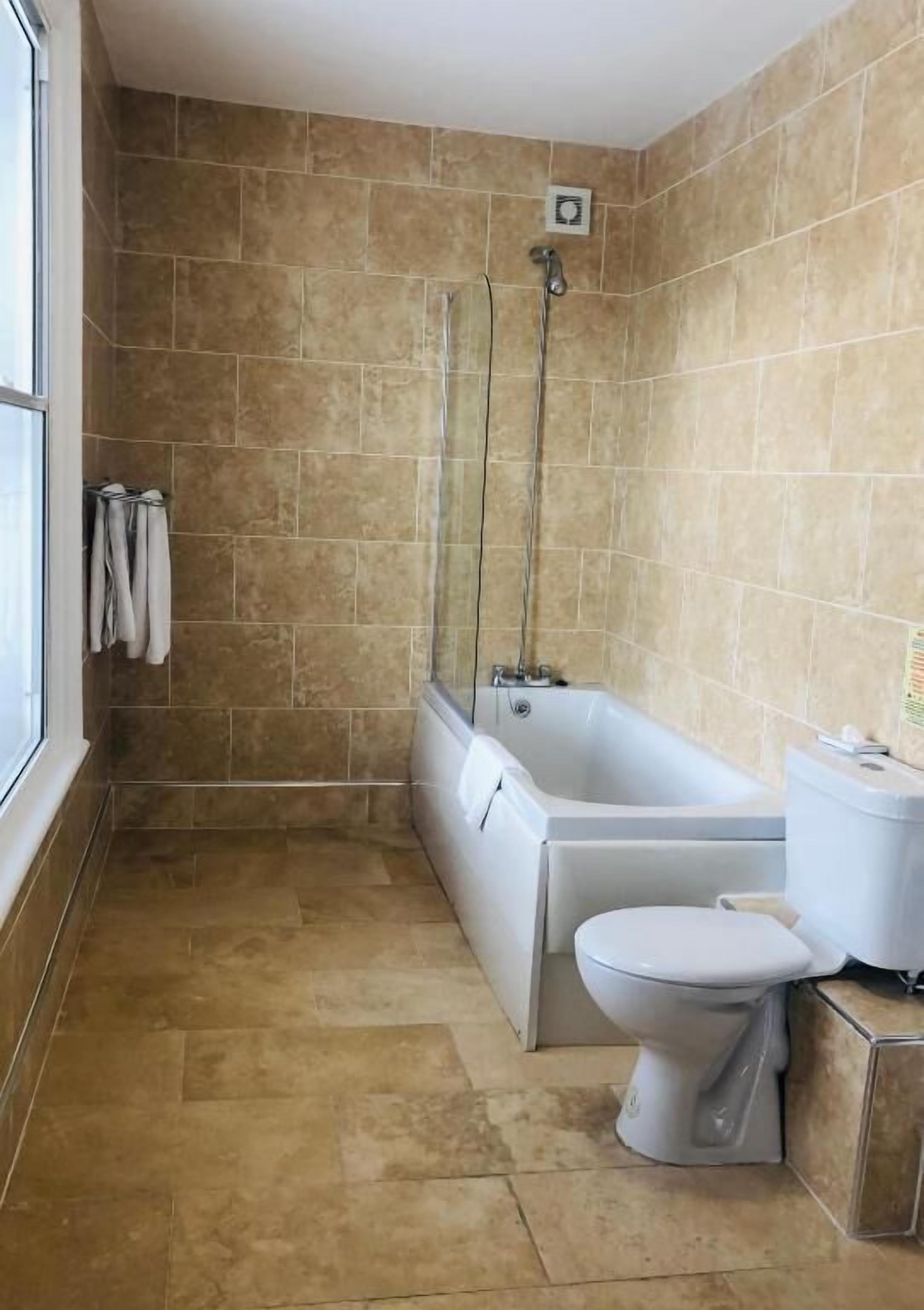 Une salle de bain avec une baignoire, des toilettes et une douche.