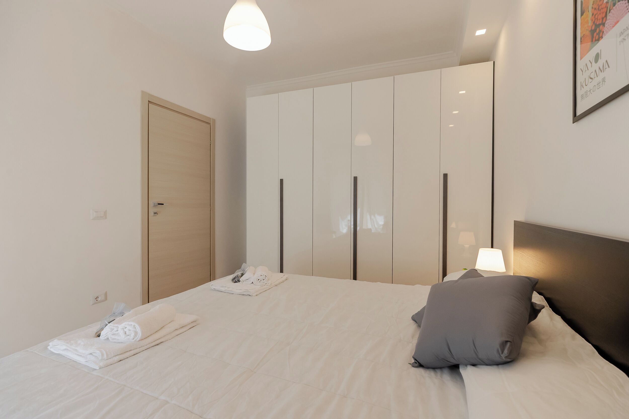 Ein Hotelzimmer mit einem Bett, einem Kleiderschrank und einer Nachttischlampe.