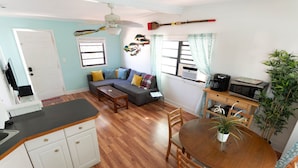 A compact living space with a kitchenette, a sofa with cushions, a dining table with chairs, and a ceiling fan. - Cindy Villa - Key Largo (Key Largo)