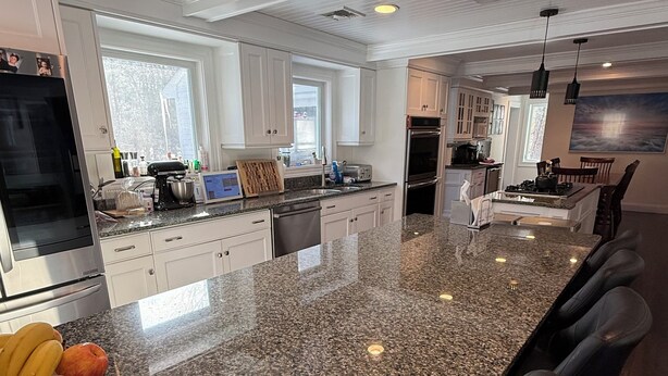 A modern kitchen with granite countertops, stainless steel appliances, and a large island with bar stools. - World Cup Stay in Easton! Elegant Suburban Escape Close to Boston Excitement (Easton)