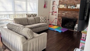 A living room with a sectional sofa, a fireplace, and a television. - World Cup Stay in Easton! Elegant Suburban Escape Close to Boston Excitement (Easton)