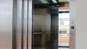 Un ascensor modern amb acabat metàl·lic i un panell de control a la dreta.