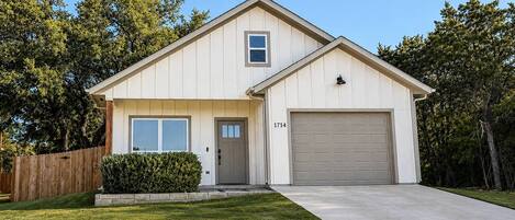 A single-story house with a garage, a front door, and a small window above the door.