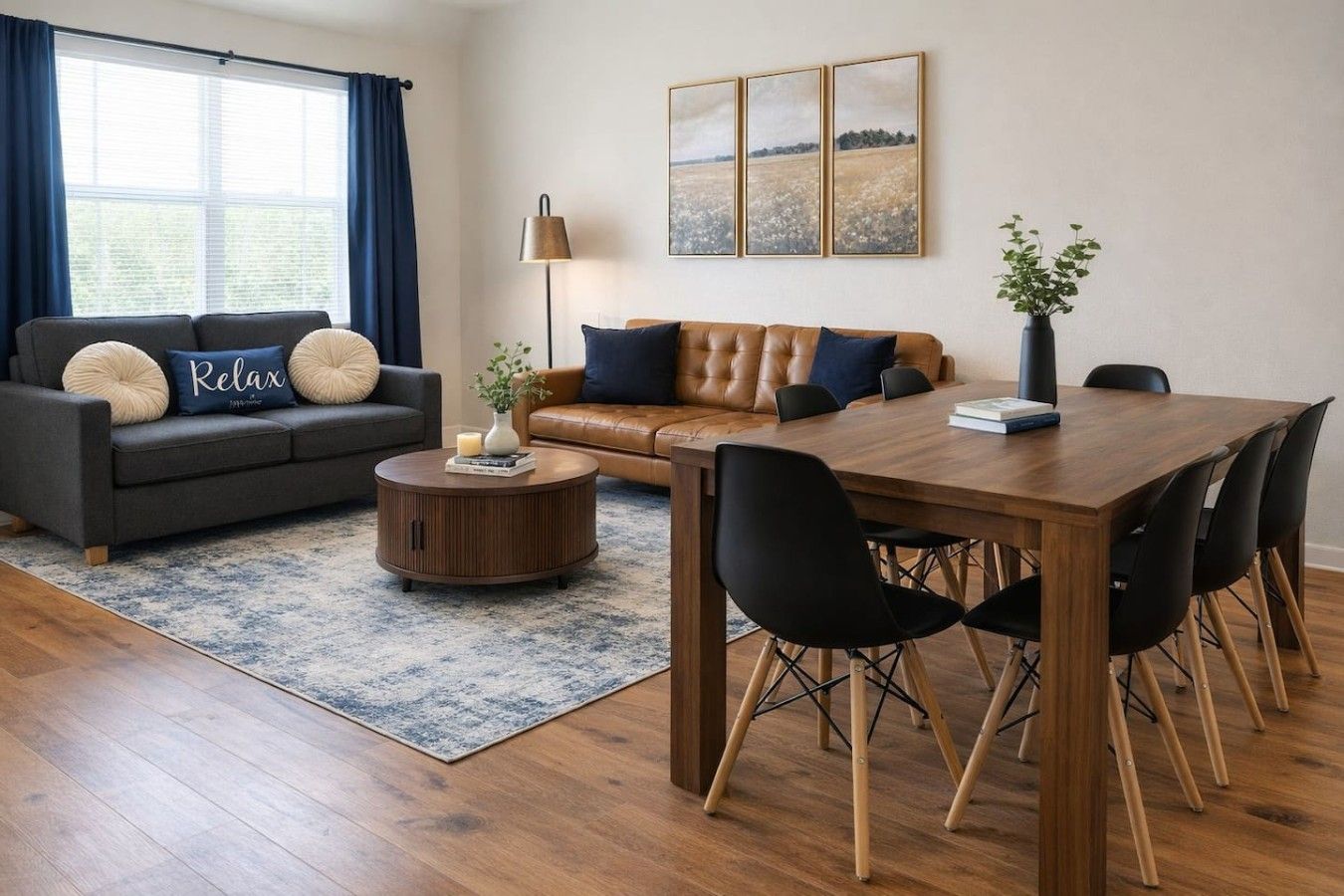 Uma sala de estar moderna com sofá, mesa de centro e mesa de jantar com cadeiras.