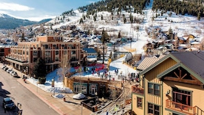 A town with a mix of modern and traditional buildings, a main street, and a snowy hillside in the background. - Studio hotel suites ski in/ski out on Main St. in Park City. Available 3/18-3/21 (Park City)