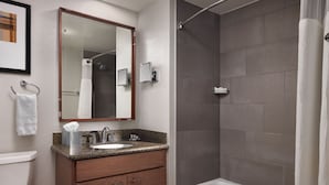 A bathroom with a sink, mirror, and shower. - Studio hotel suites ski in/ski out on Main St. in Park City. Available 3/18-3/21 (Park City)