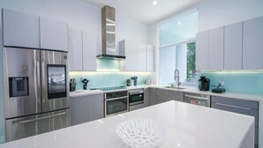Una cocina moderna con electrodomésticos de acero inoxidable, una isla grande y vistas al exterior.