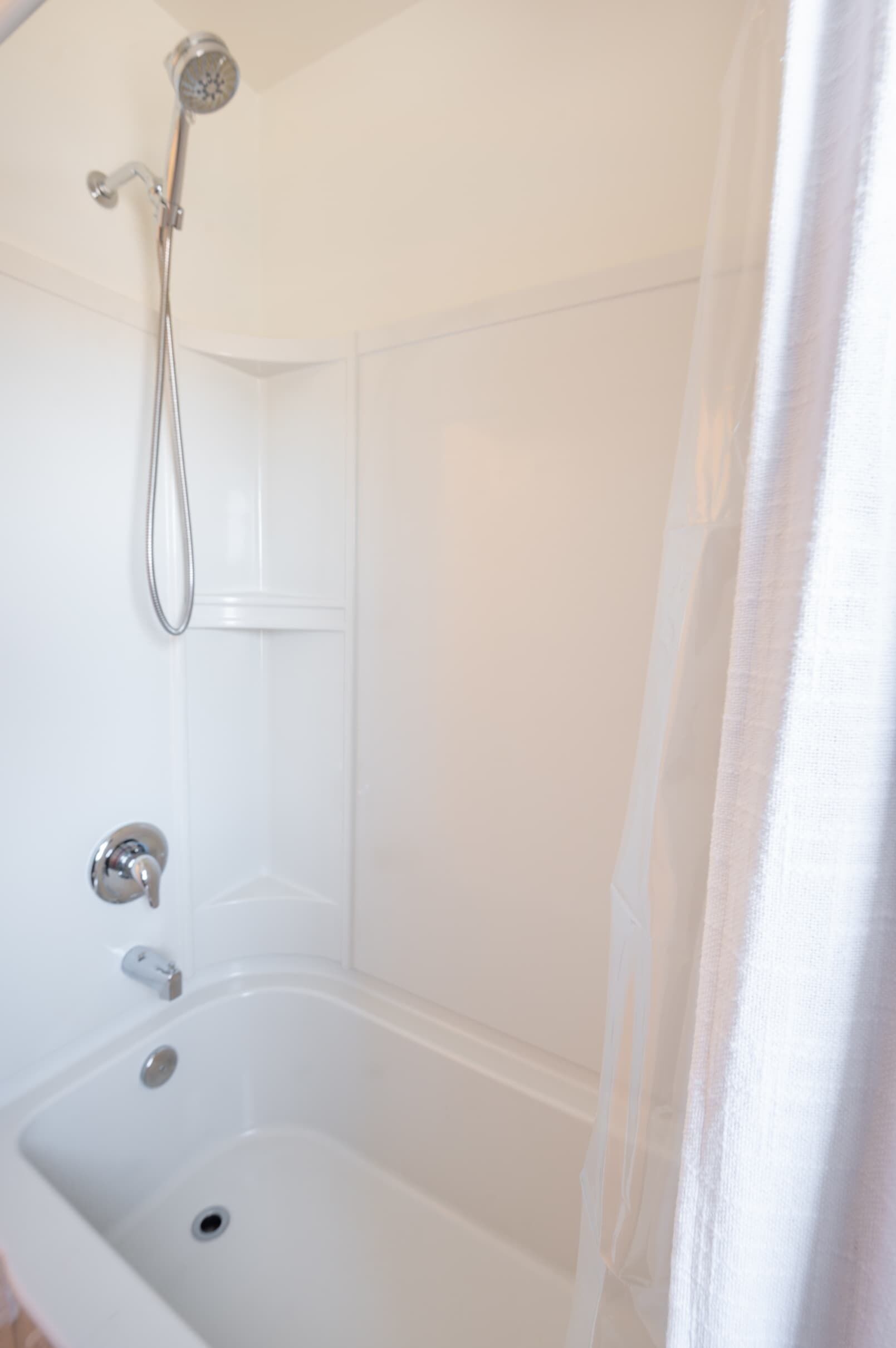 A white bathtub with a showerhead and faucet.