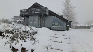 Et moderne hus med skråt tag, store vinduer og nummer 24 på døren.
