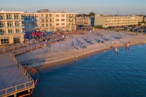 A coastal promenade with buildings and a beach. - Top Floor Luxury 3BR Beach Condo with Bay Views (Dewey Beach)