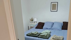 A bedroom with a bed, a nightstand, a lamp, and a framed picture on the wall. - Nice apartment in quiet neighborhood near downtown (València)