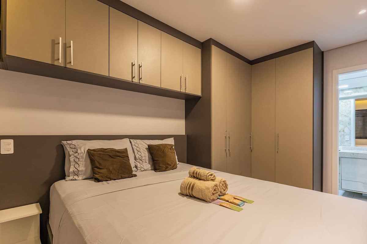 Une chambre d’hôtel avec un lit, une armoire et une fenêtre.