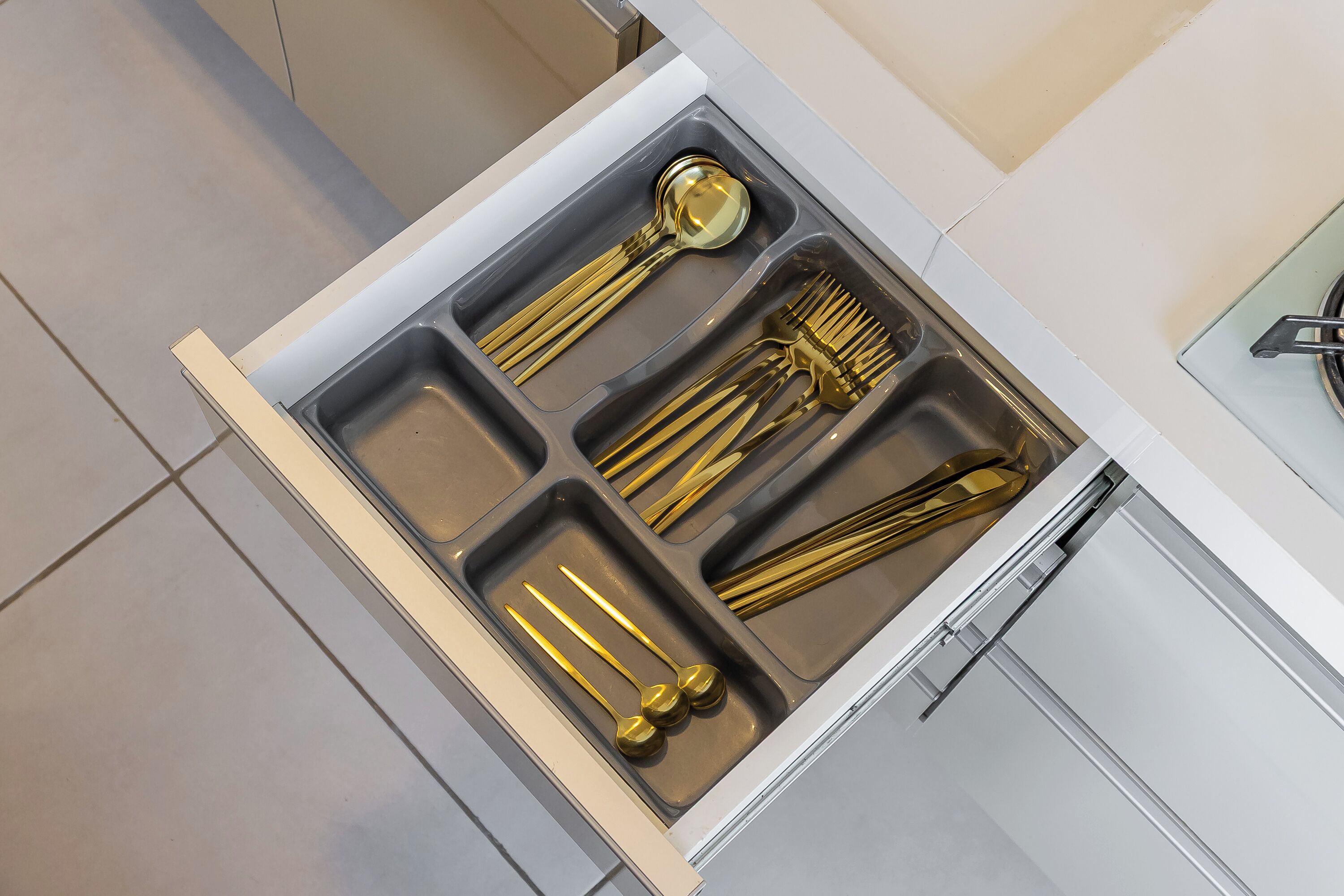 Un cajón de cocina con utensilios.