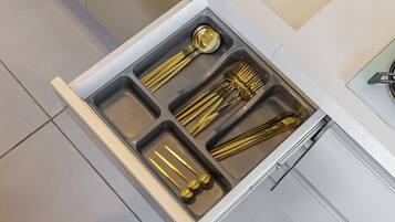 Un cajón de cocina con utensilios.