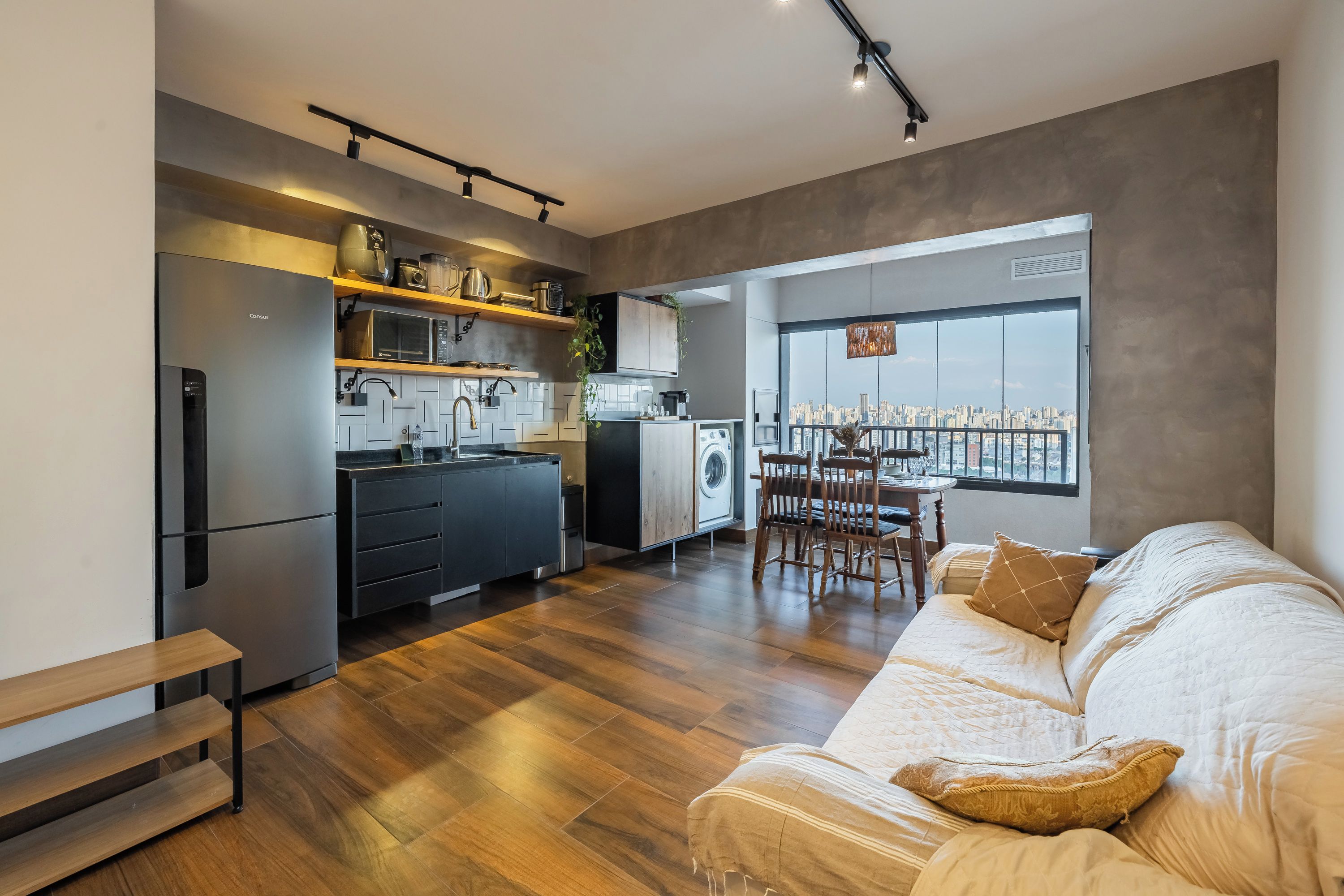 Apartamento moderno com cozinha, sala de jantar e uma grande janela com vista para a cidade.