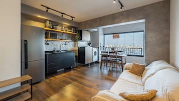 Apartamento moderno com cozinha, sala de jantar e uma grande janela com vista para a cidade.