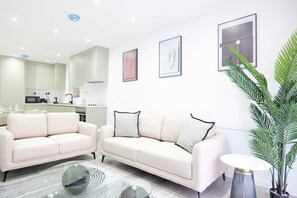 Ein modernes Wohnzimmer mit einer Couch, einem Couchtisch und einem Topfpflanzen.