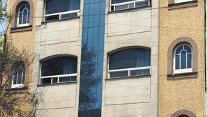 A multi-story building with a central glass facade, multiple windows, and a sign that reads 'HOTEL'. - HOTEL TORREON (Mexico City)