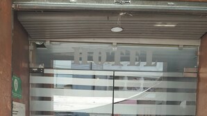 A hotel entrance with a glass door, metal handles, and a sign with the hotel's name. - HOTEL TORREON (Mexico City)