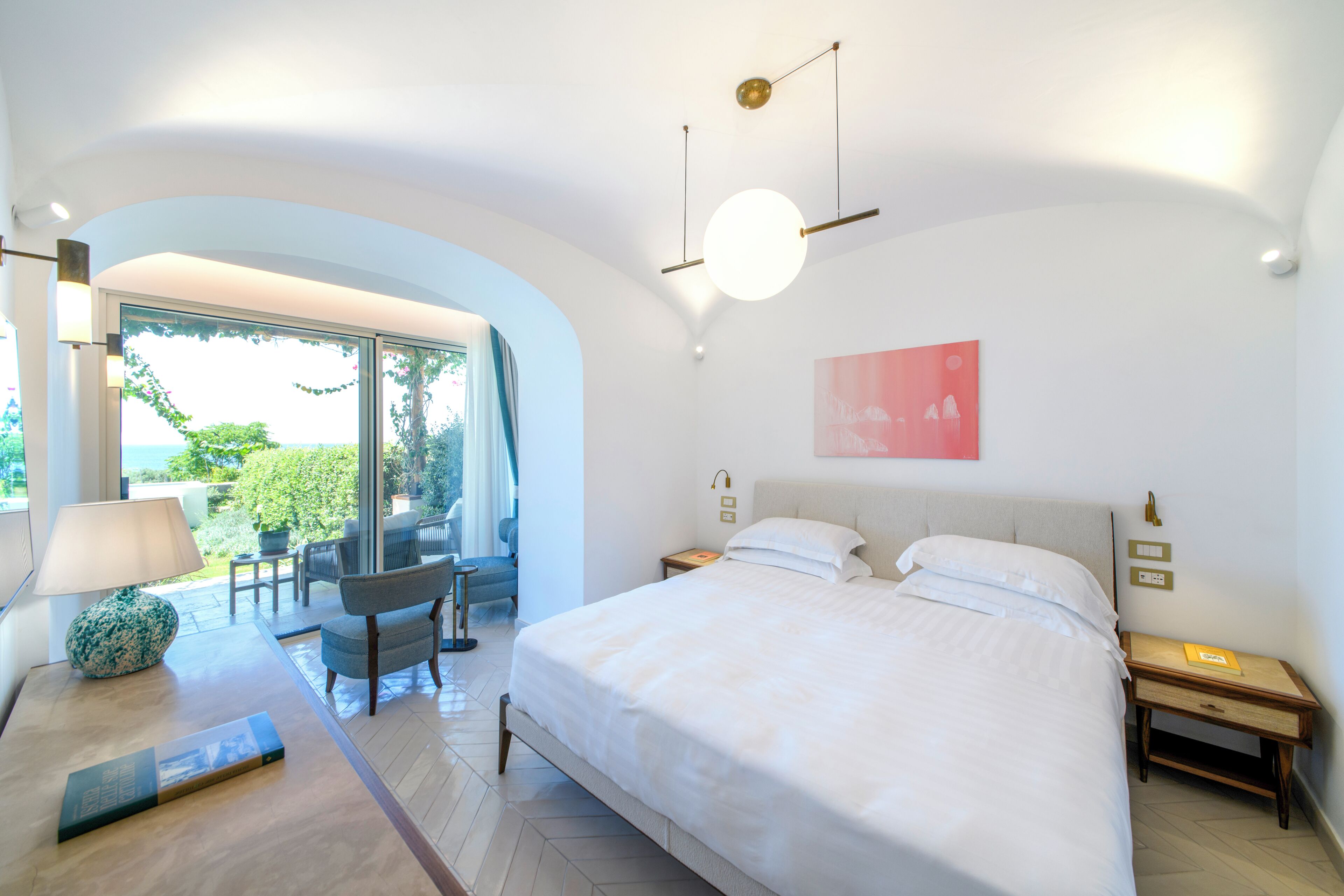 Une chambre moderne avec un grand lit, un bureau, une chaise et une vue sur l’extérieur.