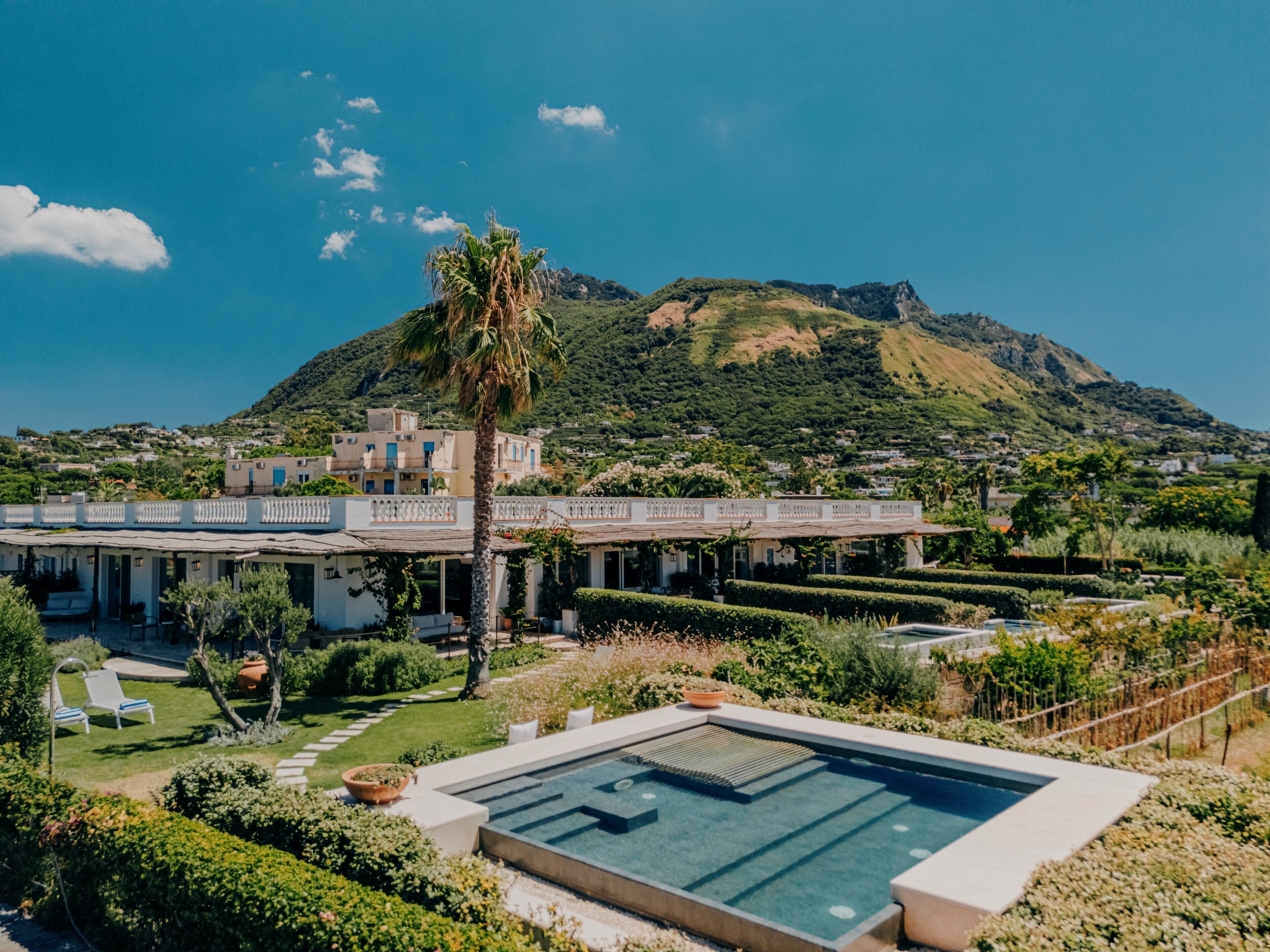 Eine moderne Villa mit Schwimmbad, üppigem Garten und Bergblick.