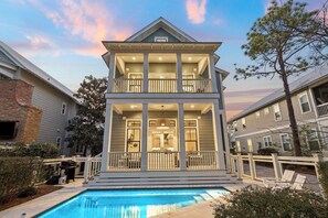 A two-story house with a balcony, a pool, and a fenced deck area. - Anna Blue| Watercolor | Private Pool | Bikes (Watercolor)