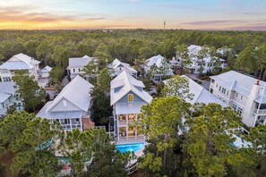 A residential area with multiple houses, a swimming pool, and a forested background. - Anna Blue| Watercolor | Private Pool | Bikes (Watercolor)