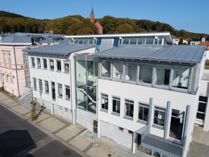En modern byggnad med flera våningar, stora fönster och en trappa som leder upp till de övre våningarna.