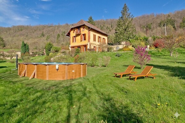 Ein zweigeschossiges Haus mit Balkon, umgeben von einem gepflegten Rasen und Garten.