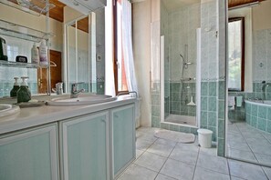 Ein Badezimmer mit einem Doppelwaschbecken, einer Dusche und einer Duschkabine.