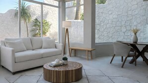 A modern living room with a white sofa, a wooden coffee table, a floor lamp, and a dining table with chairs. - Duplex w/pool+Bay & Sunset Views by Zona Romantica (Puerto Vallarta)