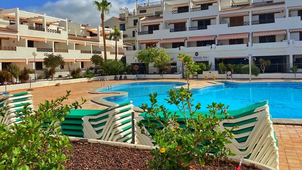 Ett hotell med en swimmingpool, flera balkonger och en poolbar som är särskilt anpassad för familjer.