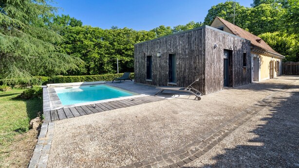 A wooden building with a pool and a patio area. - Charming 3-Star House with Heated Saltwater Pool and Private Garden (Sarlat-la-Canéda)