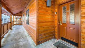 A wooden corridor with a wooden door and windows, a concrete floor, and a metal doorbell. - New Listing! Ski In/Walk to the Lift (Breckenridge)