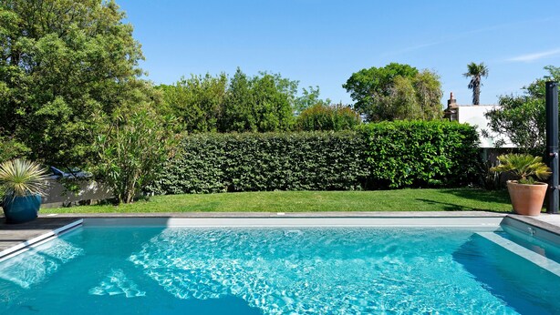 A clear blue pool surrounded by lush greenery and a well-maintained hedge. - Charming Room with Pool and Garden – Breakfast Included (Saint-Palais-sur-Mer)
