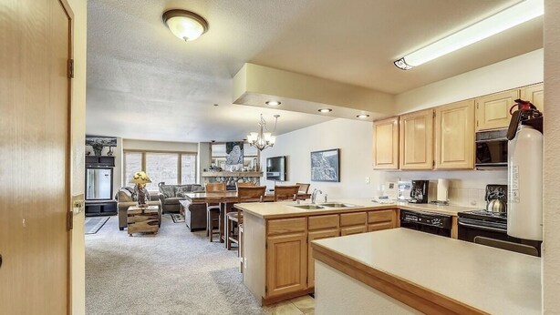 A spacious kitchen with wooden cabinets, a central island, and modern appliances. - New Listing! Ski In/Walk to the Lift/Town (Breckenridge)