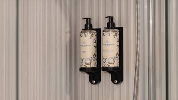 Dos botellas de champú y acondicionador Castelgel fijadas a la pared.