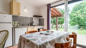 Une cuisine moderne avec un coin repas, des meubles en bois et une vue sur l’extérieur.