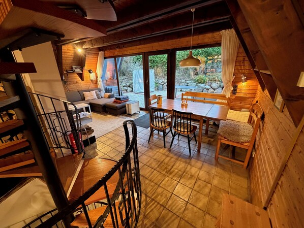 Un intérieur en bois comprenant un canapé, une table à manger, des chaises et un escalier.