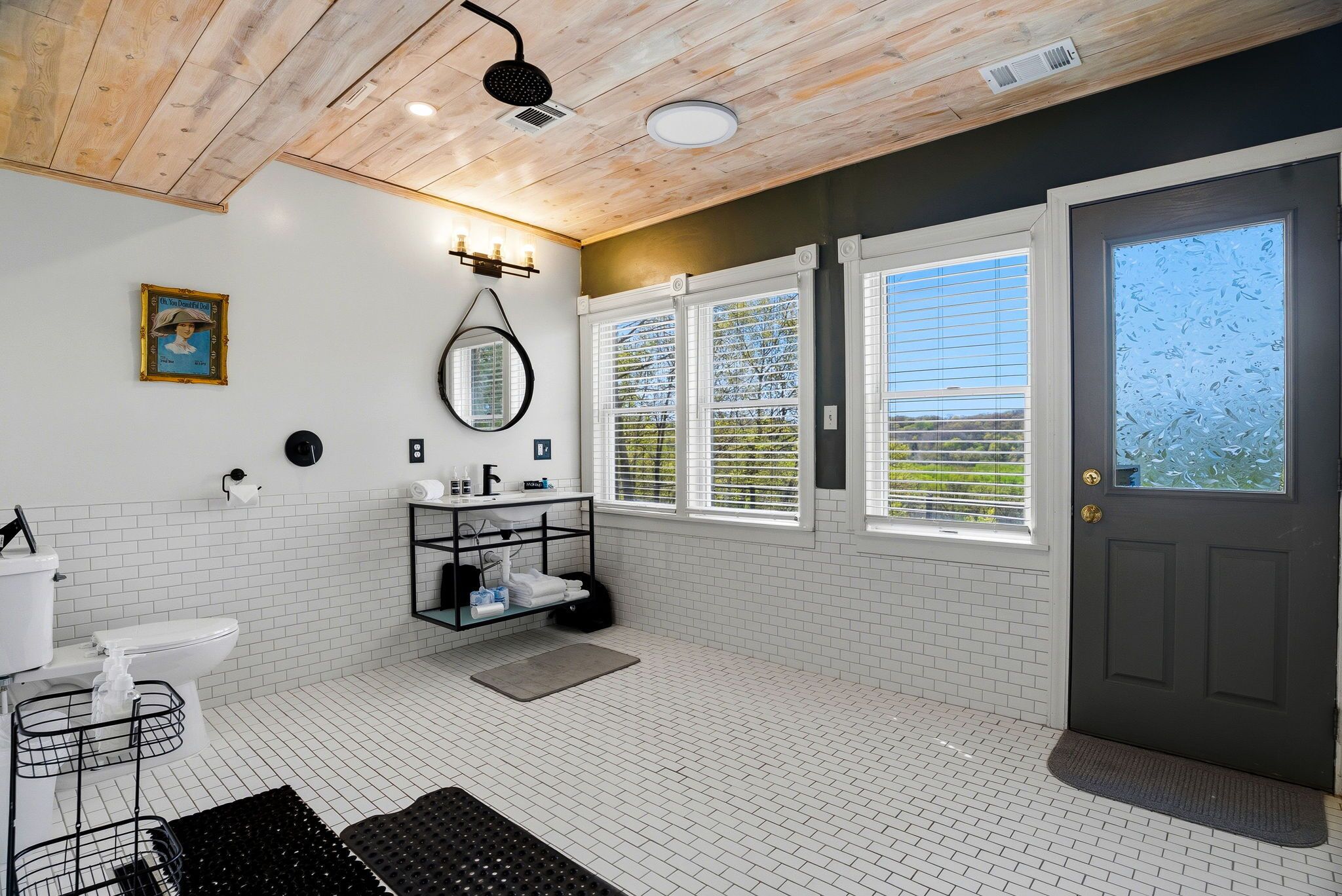 A bathroom with a toilet, sink, shower, and a towel rack.