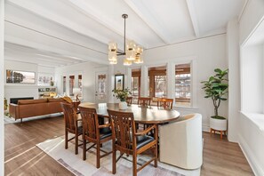 A dining area with a round table, wooden chairs, and a chandelier. - Featherstone (White Bear Lake)