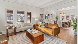A spacious living room with a sofa, coffee table, and dining area.
