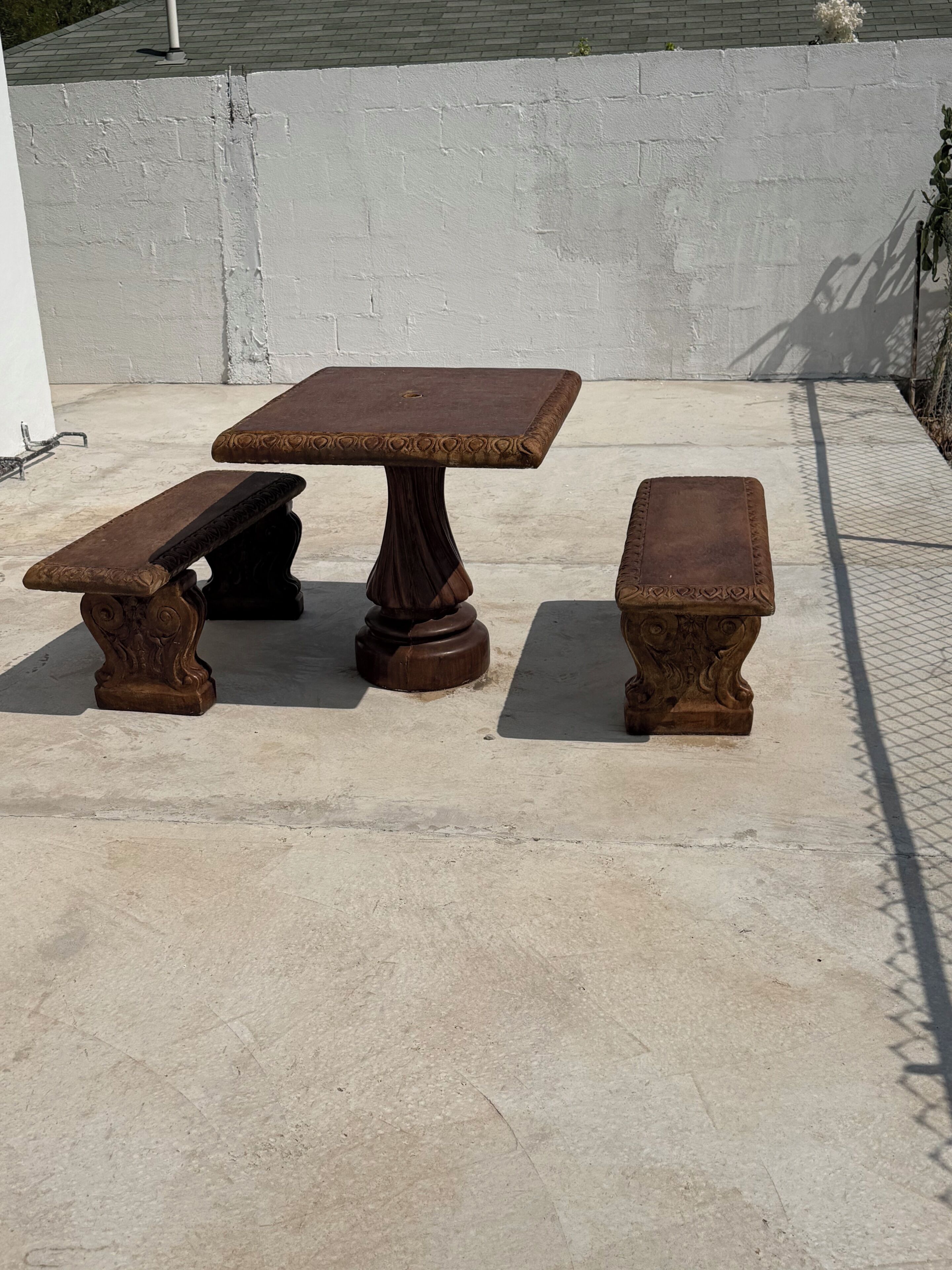 Een terras met een tafel en twee bankjes.