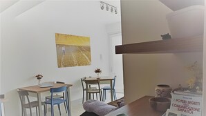 A modern room with a dining table, chairs, a sofa, a decorative bowl, and a framed picture on the wall. - Villa Degli Alberi with Garden, Private Terrace, Wi-Fi and Air Conditioning (Buseto Palizzolo)