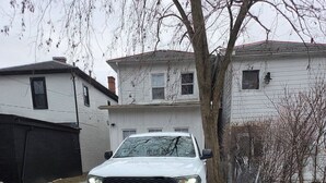 A white car parked on a paved driveway in front of a house. - Boutique Italian Village | OSU | 4BR | + 2 parking (Columbus)