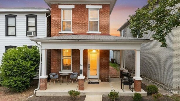 A two-story brick house with a covered patio and a front door. - Boutique Italian Village | OSU | 4BR | + 2 parking (Columbus)